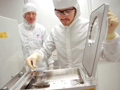 Student and professor in Montana Microfabrication Facility cleanroom wearing white cleansuits