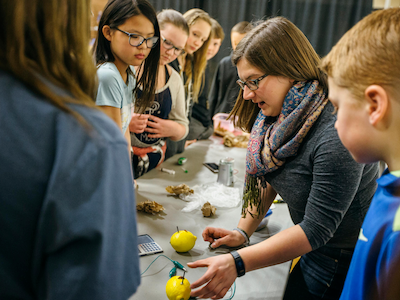 MSU woman student and younger kids interacting during Engineerathon event